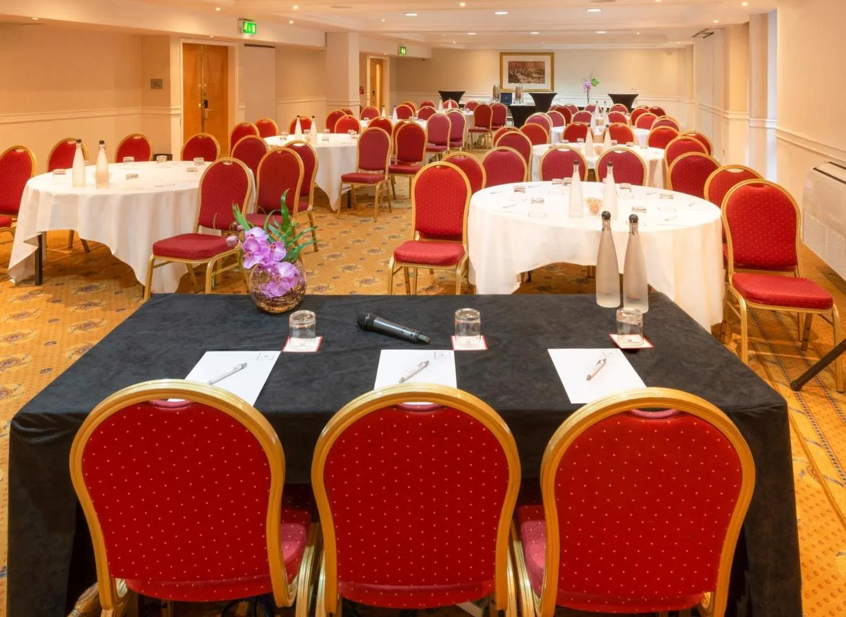 a conference room with tables and red chairs at Millennium Hotel and Conference Centre Gloucester London in London