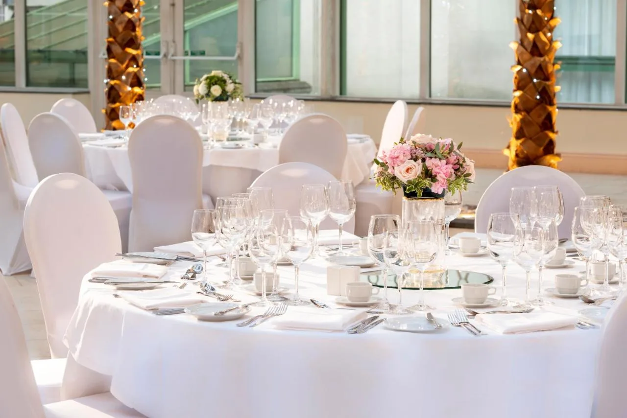 a table set up for a wedding with white tables and chairs at Millennium Hotel and Conference Centre Gloucester London in London